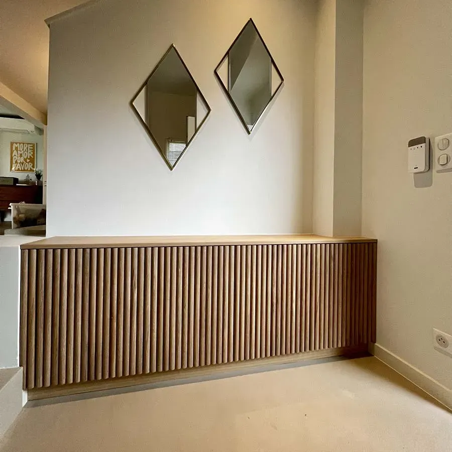 Rangement en bois le long d'un mur et miroirs en losange