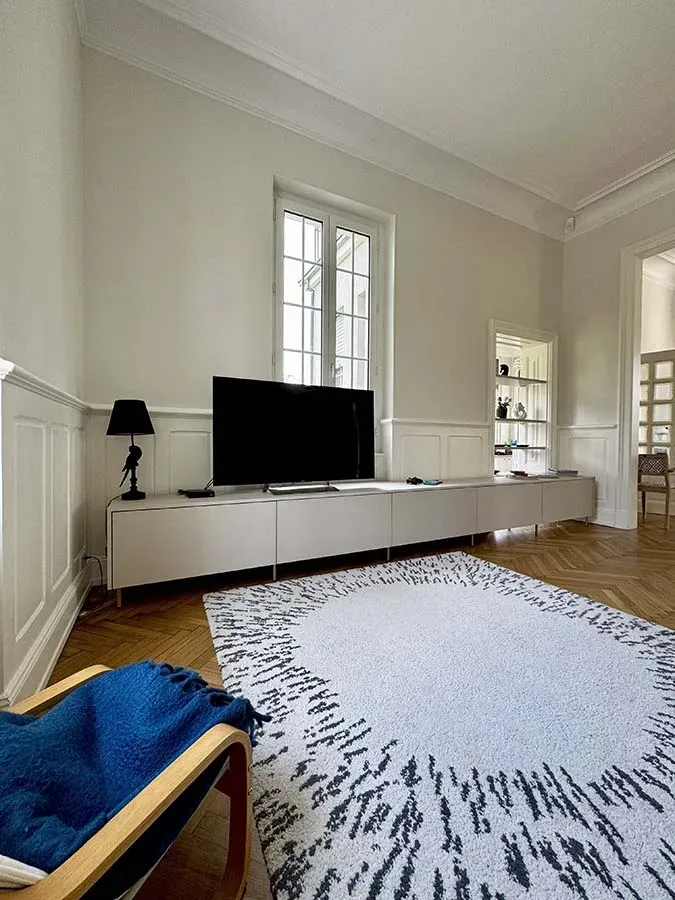 Salon avec tapis et long meuble télé